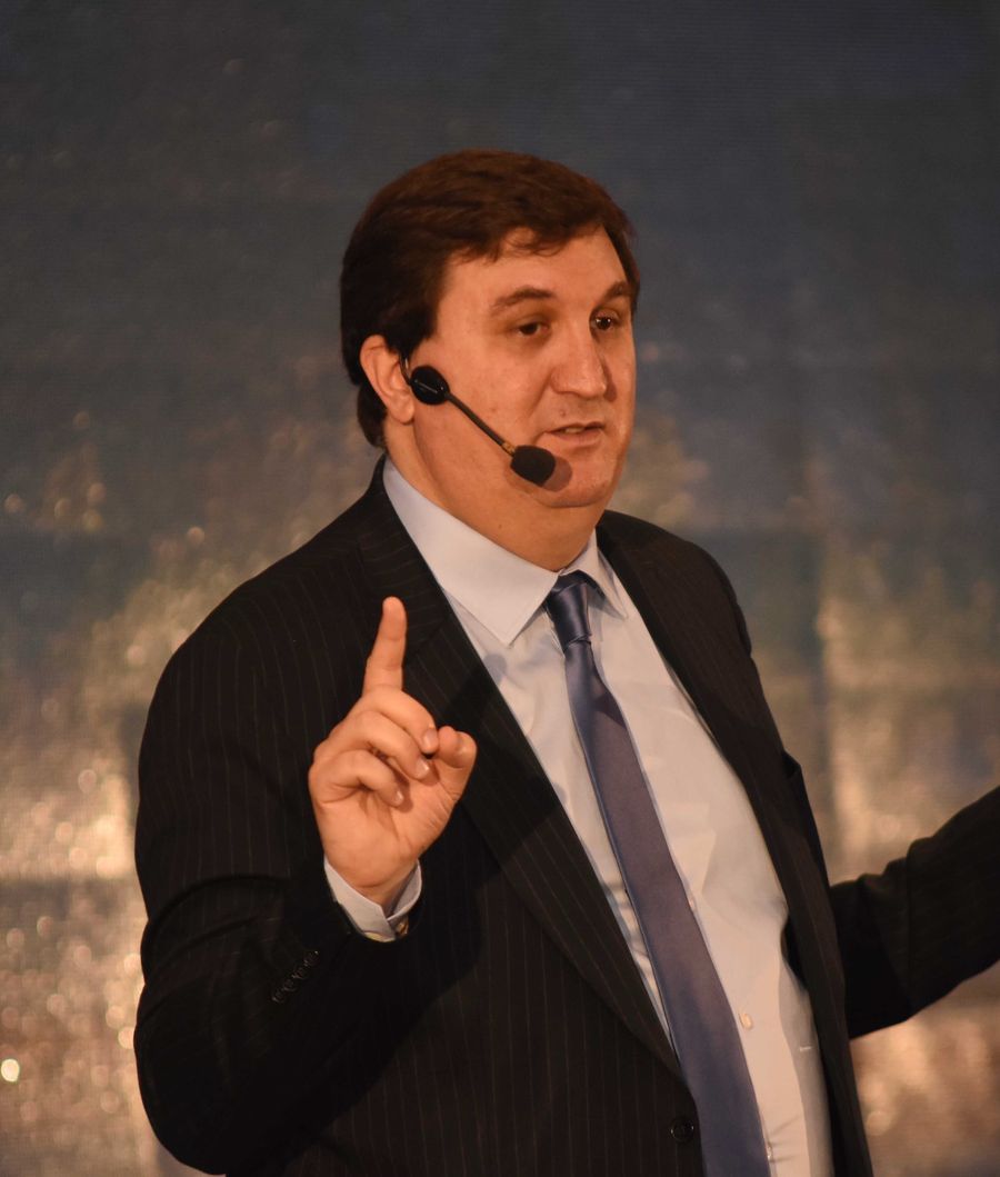 Mariano remarcando una idea en el escenario, con el control de presentación en la mano